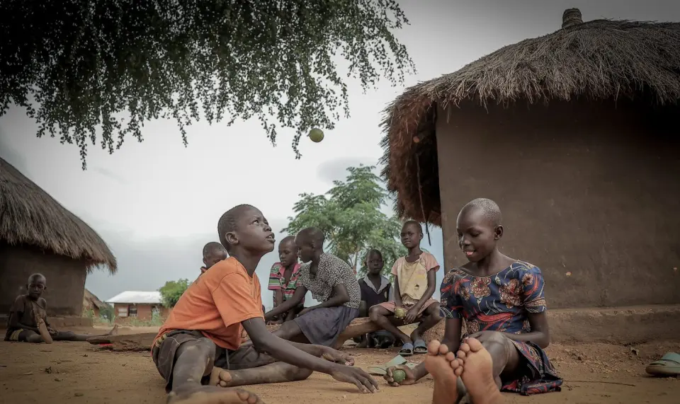 Children playing a game outside their homes in Yumbe