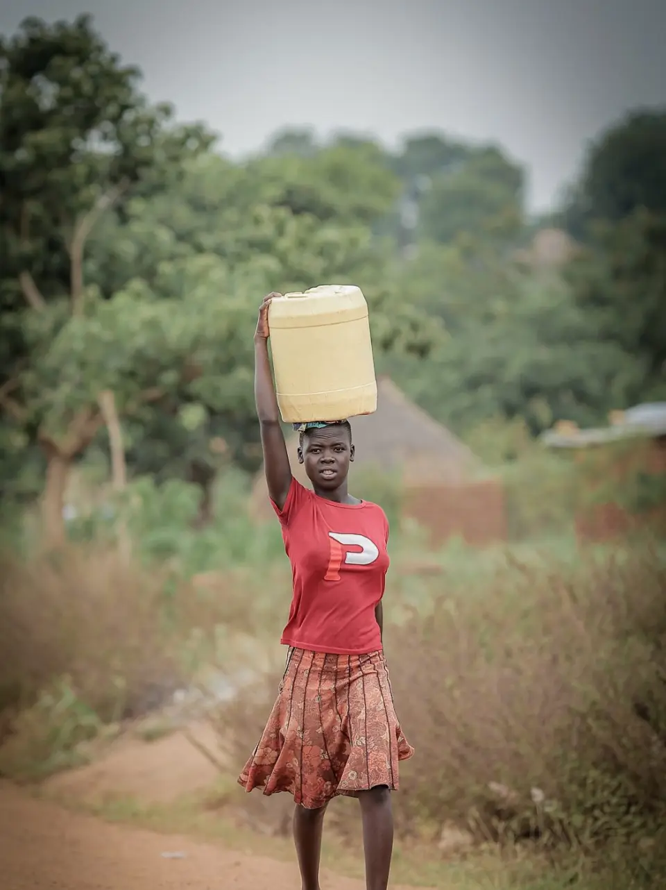 A girl carrying a jerrycan on her head