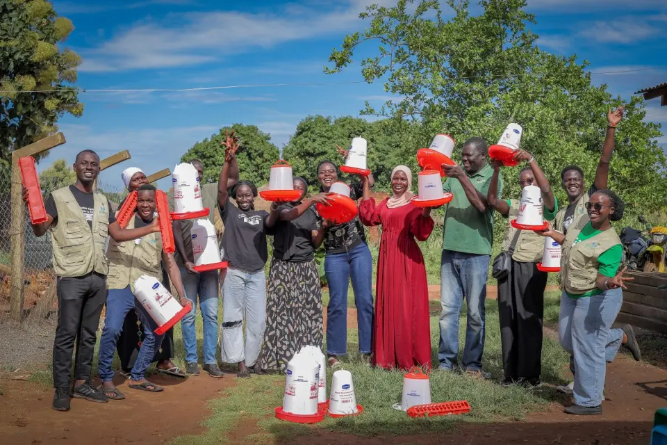 Programme participants celebrating with new poultry feeders in Yumbe