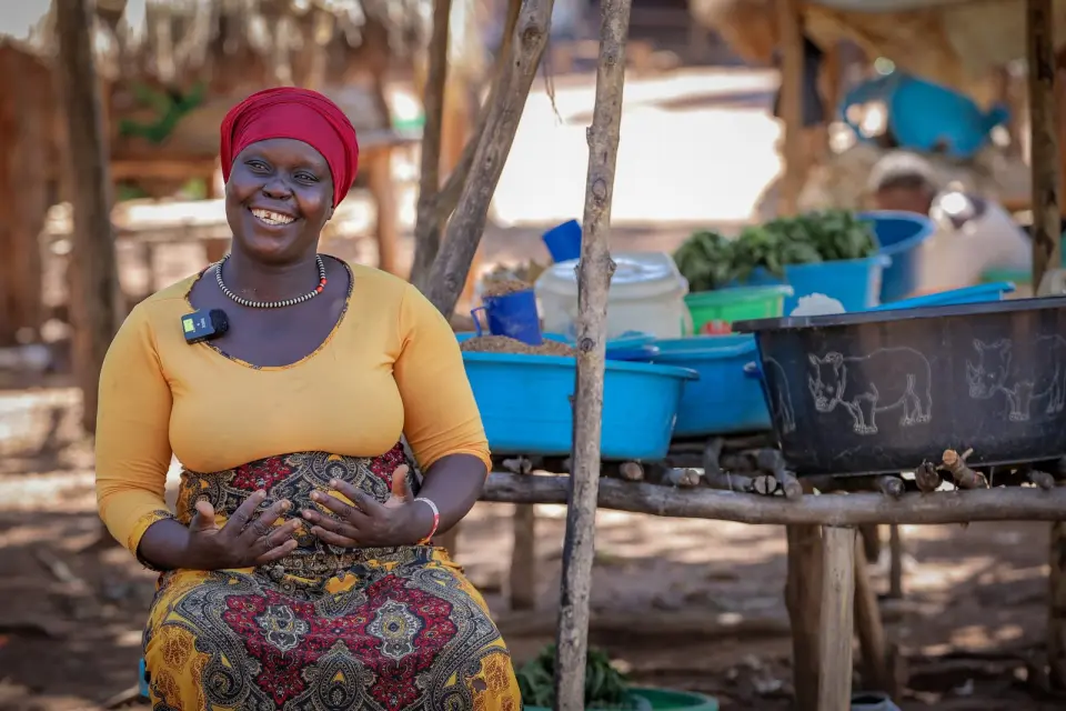 A smiling woman at her market stall