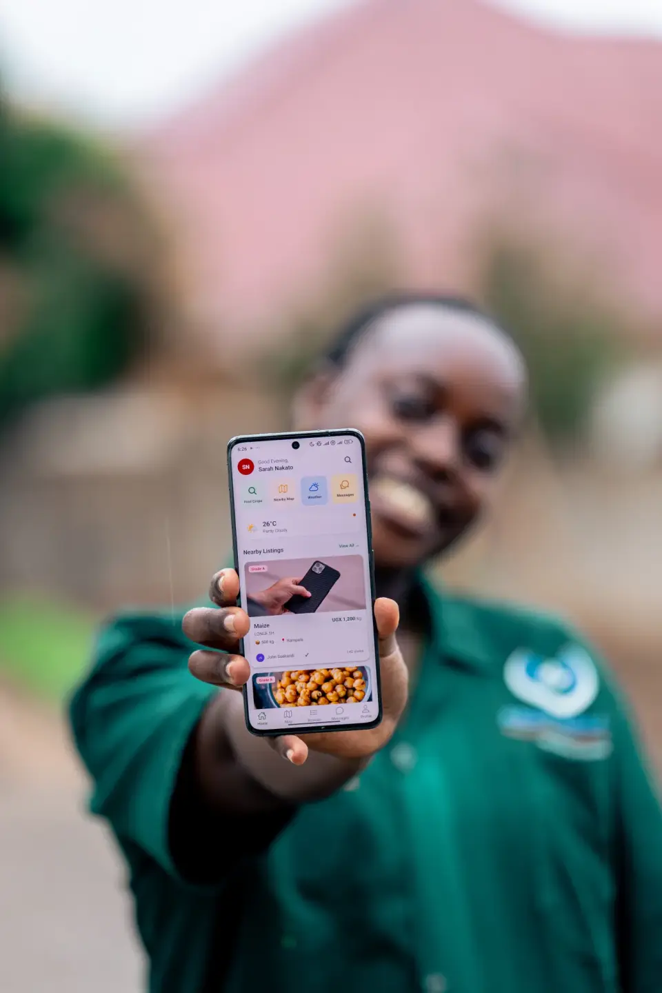 A person holding up a phone showing the Agribusiness Connekt app