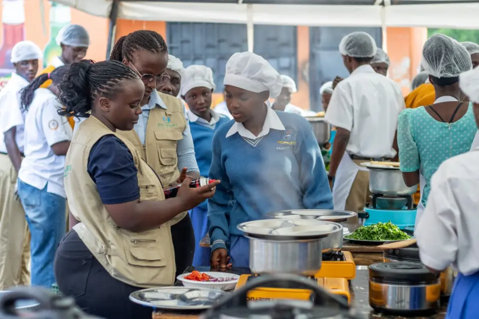 BetterLife team members with students at clean cooking stoves during a school cook-off