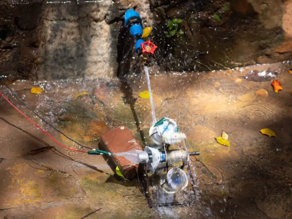 A small water turbine, wired up and turning in the flow from a spring