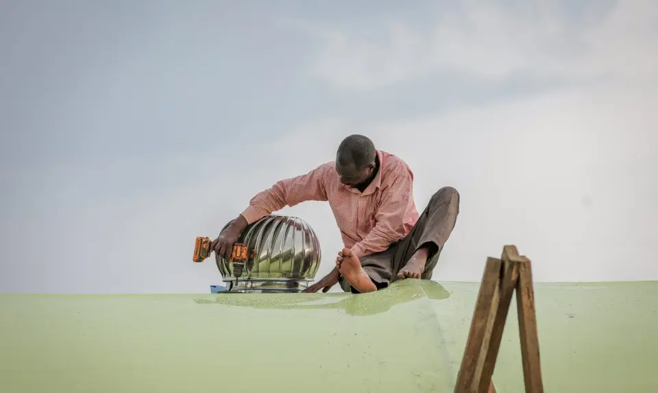 Fitting a roof vent on the greenhouse in Yumbe