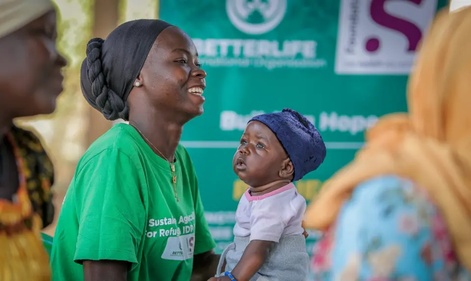 A mother laughing with her baby at a programme session in Yumbe