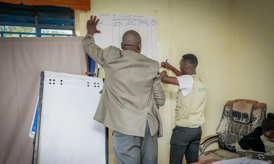 A trainer at a flip chart during a session in Yumbe