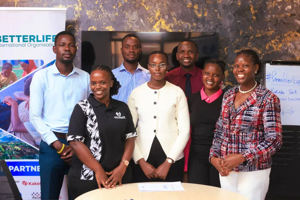 Seven members of the BetterLife and Kakebe teams standing together beside a BetterLife banner